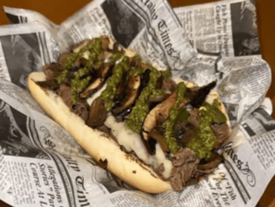 A loaded prime-rib Philly wrapped in newsprint